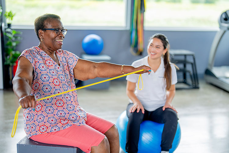 Senior woman uses resistance band during physical therapy session in Shreveport