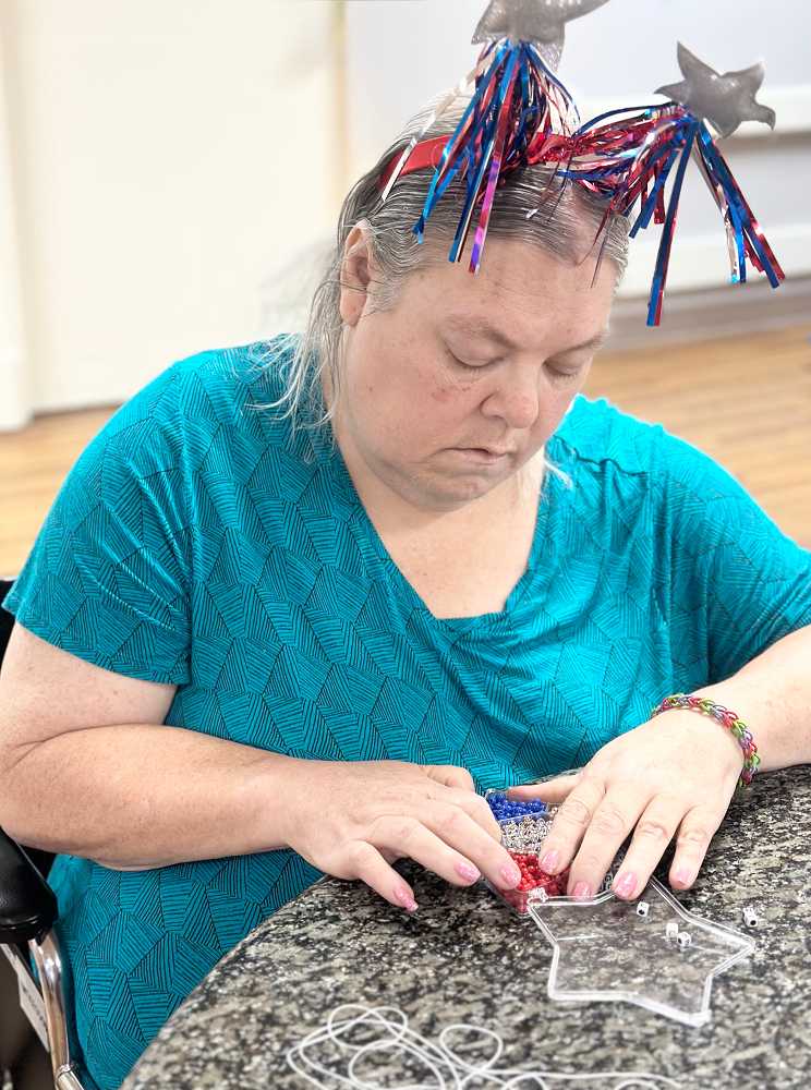 A woman creates a star shape with a ribbon during a dementia care activity in Shreveport, LA.