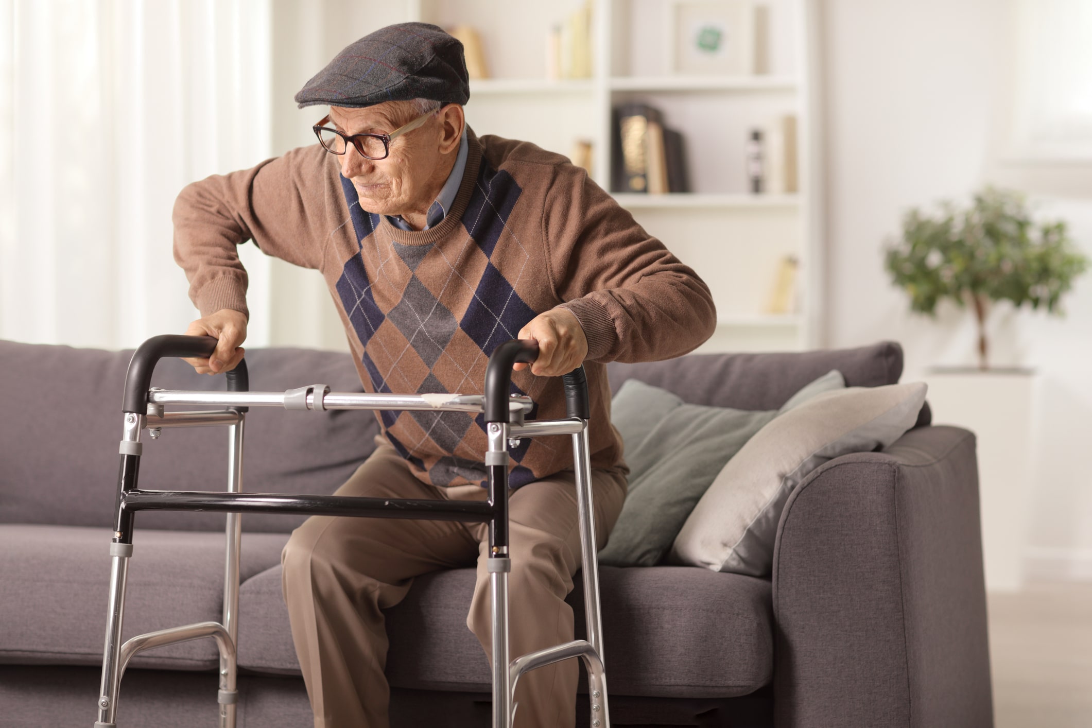 An elderly man rests on a sofa during post-operative recovery