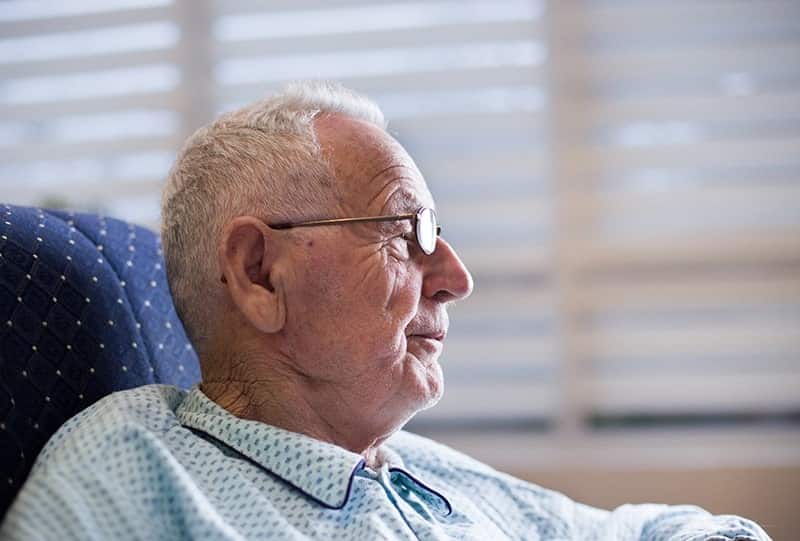 A caregiver holding the hand of a hospice patient