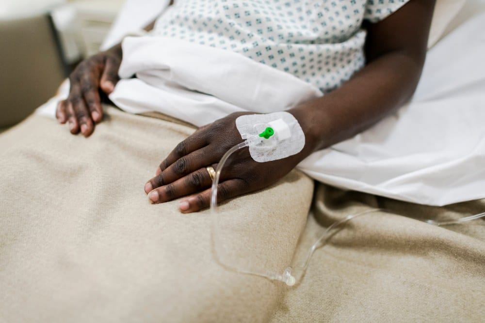 A patient in a bed, receives antibiotics through an IV at a skilled nursing facility