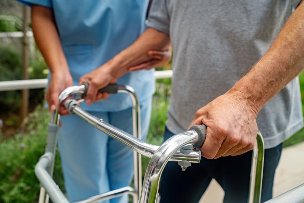 Someone with a walker after hip surgery with a nurse at a skilled nursing facility