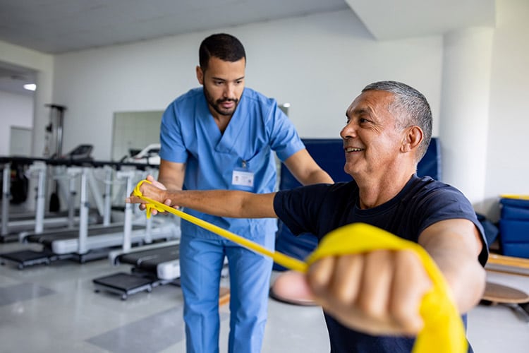 Man holds a yellow rope beside another man related to Respiratory Rehabilitation