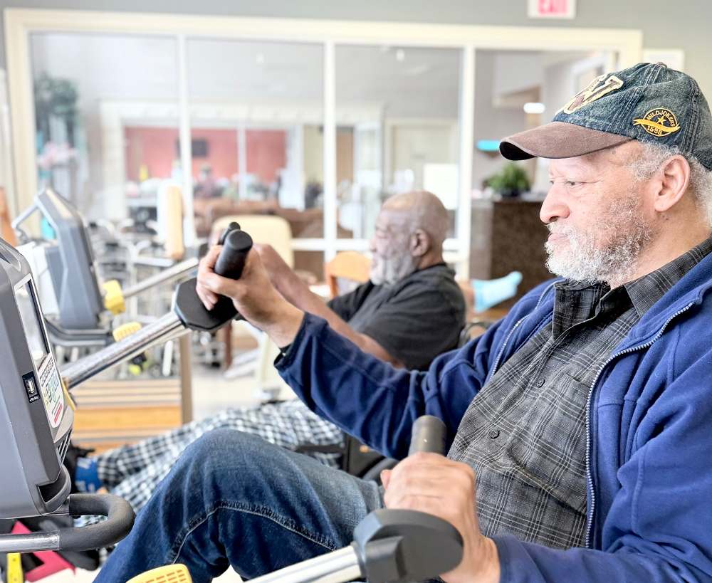 Two older senior citizens are receiving short-term rehabilitation in physical therapy in a skilled nursing facility