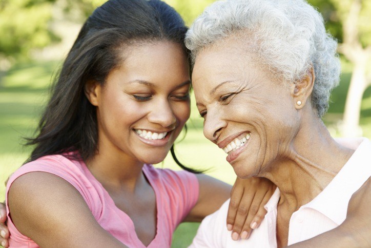 An older woman and a young woman smiling together while in respite care in a nursing home